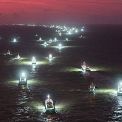 Barcos pesqueros zarpan al amanecer desde Lianyungang, provincia de Jiangsu, en el este de China. | Foto:CN-STR / AFP