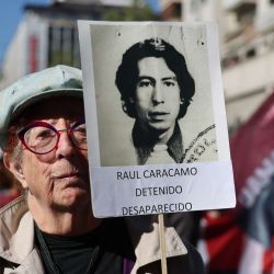 La chilena Sara Canales sostiene un cartel con la foto de una amiga desaparecida, víctima de la dictadura de Augusto Pinochet (1973-1990), durante una marcha conmemorativa hacia el Cementerio General de Santiago. El próximo 11 de septiembre se conmemora el 53.º aniversario del golpe militar liderado por el fallecido dictador Augusto Pinochet contra el entonces presidente de Chile, Salvador Allende, cuyo gobierno autoritario dejó miles de víctimas. | Foto:Javier Torres / AFP