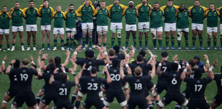 Jugadores sudafricanos observan a jugadores neozelandeses realizar el Haka durante el tercer partido internacional de rugby union de la Gran Rivalidad del Rugby entre Sudáfrica y Nueva Zelanda en el estadio FNB de Johannesburgo.