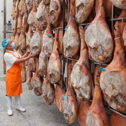 Imagen de un empleado inspeccionando jamones usados para elaborar pasteles de luna, en la ciudad de Xuanwei, en la provincia de Yunnan, en el suroeste de China. Los productores de pasteles de luna en Xuanwei trabajan a plena capacidad para elaborar pasteles de luna antes del próximo Festival del Medio Otoño. | Foto:Xinhua/Chen Xinbo
