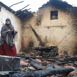 Una mujer inspecciona su casa dañada tras ser arrasada por un incendio forestal en Bordj T'har, una localidad y comuna de la provincia de Jijel, en el noreste de Argelia. | Foto:AFP