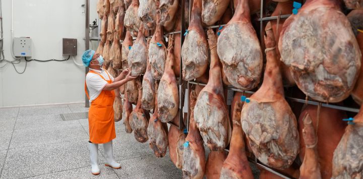 Imagen de un empleado inspeccionando jamones usados para elaborar pasteles de luna, en la ciudad de Xuanwei, en la provincia de Yunnan, en el suroeste de China. Los productores de pasteles de luna en Xuanwei trabajan a plena capacidad para elaborar pasteles de luna antes del próximo Festival del Medio Otoño.