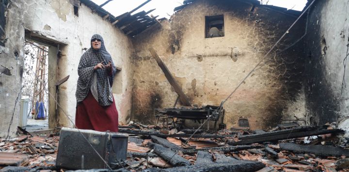 Una mujer inspecciona su casa dañada tras ser arrasada por un incendio forestal en Bordj T'har, una localidad y comuna de la provincia de Jijel, en el noreste de Argelia.