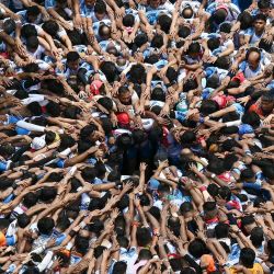 Devotos hindúes se preparan para formar una pirámide humana con el fin de romper una olla de yogur suspendida en el aire durante la celebración del festival Krishna Janmashtami en Mumbai. | Foto:Indranil Mukherjee / AFP