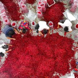 Habitantes de una aldea clasifican chiles en una planta procesadora de pimientos picantes en Heixi, en el municipio de Chongqing, en el suroeste de China. | Foto:CN-STR / AFP