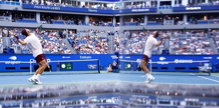 El argentino Francisco Cerundolo saca contra el belga Alexander Blockx, reflejado en el espejo de un equipo de televisión, durante su partido de octavos de final individuales masculinos en el noveno día del torneo de tenis US Open en el Centro Nacional de Tenis USTA Billie Jean King en la ciudad de Nueva York.