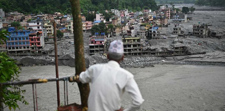 Un hombre observa los restos tras las inundaciones repentinas en Trishuli, distrito de Nuwakot, Nepal. El derrumbe de glaciares y montañas ocurrido el 26 de agosto en la frontera entre China y Nepal causó la muerte de al menos 1398 personas y dejó más de 5500 desaparecidas, entre ellas unos 800 extranjeros.