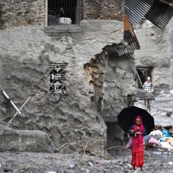Una mujer camina entre los restos dejados por las repentinas inundaciones en el distrito nepalí de Nuwakot. La enorme ola de agua helada y escombros, provocada por el colapso de un glaciar en la frontera entre China y Nepal, causó la muerte de al menos 939 personas y dejó a cerca de 4.500 desaparecidas; Katmandú ha advertido que los costos de reconstrucción podrían ascender a "miles de millones de dólares". | Foto:ARUN SANKAR / AFP