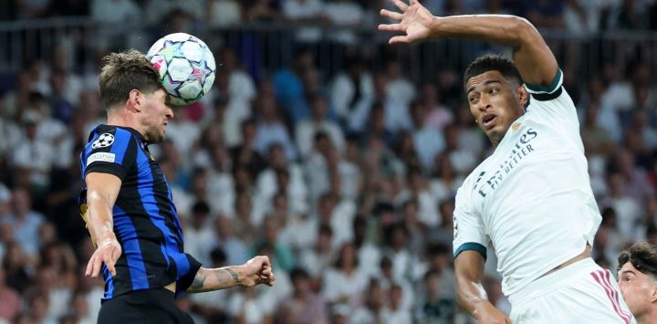 El defensor inglés del Inter de Milán, John Stones, cabecea la pelota ante la presión del centrocampista inglés del Real Madrid, Jude Bellingham, durante el partido de la primera jornada de la fase de grupos de la Liga de Campeones de la UEFA entre el Real Madrid y el Inter de Milán, disputado en el estadio Santiago Bernabéu de Madrid.
