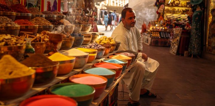Un vendedor de especias se sienta en su tienda en el antiguo zoco de Dubai.