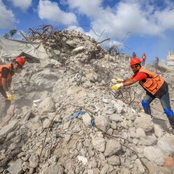 Personal de Defensa Civil remueve los escombros de la torre Al-Muhandisin —destruida por ataques israelíes al inicio de la guerra entre Israel y el grupo militante palestino Hamás— en busca de restos humanos en el campamento de refugiados de Nuseirat, en el centro de la Franja de Gaza. Gaza sigue sumida en una violencia cotidiana, con el ejército israelí y Hamás acusándose mutuamente de violar la tregua vigente desde el 10 de octubre. La guerra arrasó extensas zonas del territorio, desplazó a la mayor parte de la población al menos una vez y dejó a cientos de miles de personas viviendo en tiendas de campaña y refugios temporales. | Foto:Eyad Baba / AFP