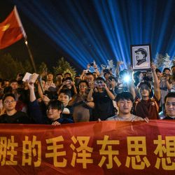 Un hombre sostiene un retrato del fallecido líder comunista Mao Zedong mientras la gente se reúne para rendir homenaje en la Plaza de la Estatua de Bronce de Shaoshan, en la provincia china de Hunan (centro del país), un día antes del 50.º aniversario de su muerte. | Foto:Hector Retamal / AFP