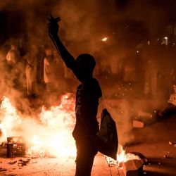 Un manifestante permanece junto a una barricada en llamas durante una protesta por la crisis eléctrica y los persistentes cortes de luz que afectan al país, en Brusubi. Miles de personas salieron a las calles durante la noche en Gambia, quemando neumáticos y coreando consignas contra el presidente en protesta por los apagones que aquejan al país desde junio y que recientemente se han agravado. Los cortes de electricidad rotativos, que se producen durante la temporada de calor, han llegado a durar hasta 48 horas en algunas zonas. | Foto:MUHAMADOU BITTAYE / AFP