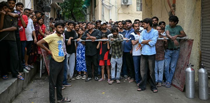 La gente se reúne para observar las labores de búsqueda del equipo de rescate tras el derrumbe de un edificio en la zona de Satya Niketan, en Nueva Delhi, India. El colapso de un edificio en la capital india, Nueva Delhi, causó la muerte de al menos tres personas, según informaron medios locales, mientras las autoridades trabajaban para rescatar a los atrapados entre los escombros.