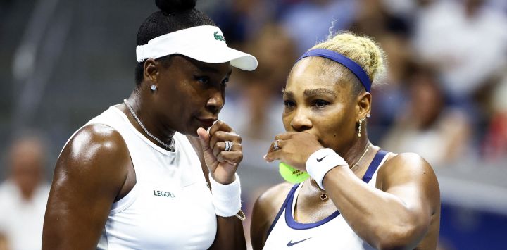Las estadounidenses Serena Williams (derecha) y Venus Williams conversan durante su partido de dobles femeninos contra la australiana Maya Joint y la taiwanesa Chan Hao-ching, en la sexta jornada del torneo de tenis US Open, en el USTA Billie Jean King National Tennis Center de Nueva York.