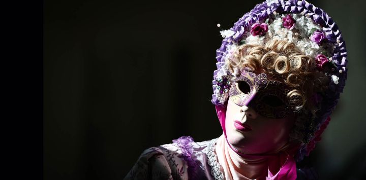 Una persona vestida con un traje veneciano participa en un desfile por las calles de la localidad durante la 20.ª edición de «Les Flaneries au Miroir», un encuentro de trajes de estilo veneciano, en Martigues, sureste de Francia.