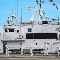 Personal de la Guardia Costera de Filipinas, equipado con trajes de protección, traslada las bolsas con los cuerpos de las víctimas del incendio de un ferry hacia una carpa para su identificación en el puerto de Borac, en la provincia de Palawan. La cifra de fallecidos por el incendio del ferry filipino se elevó a 76, después de que la Guardia Costera confirmara el hallazgo de otros 41 cuerpos a bordo de la embarcación calcinada. | Foto:JAM STA ROSA / AFP