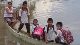 Chicos cruzando el Riachuelo en bote