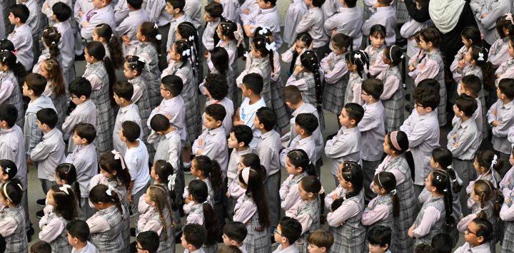 Estudiantes llegan para el primer día de clases tras las vacaciones de verano de tres meses en la ciudad de Kuwait.