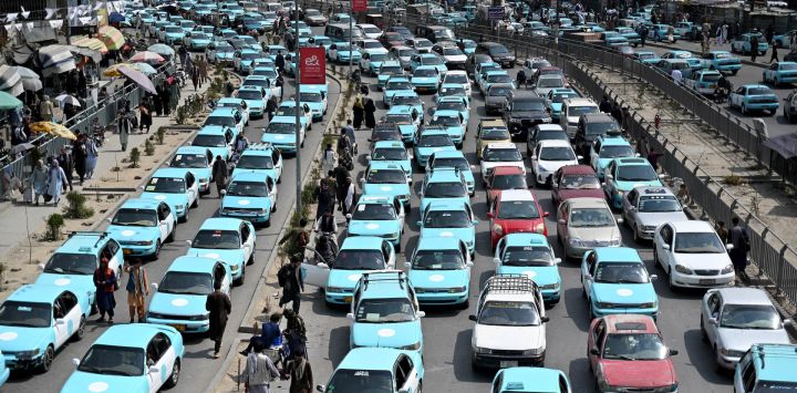 Pasajeros en taxis azules aguardan en un atasco en Kabul, Afganistán.