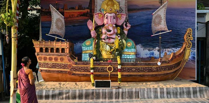 Una mujer reza ante una imagen de la deidad hindú Ganesha —con cabeza de elefante—, colocada sobre una maqueta de una embarcación pesquera durante el festival «Ganesh Chaturthi» en Chennai