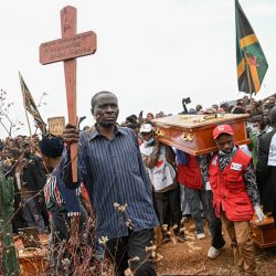 Bafunyembaka Lusirha llega al cementerio de Ruzizi portando la cruz de su hija, Mugoli Bafunyembaka, de 9 años, fallecida en un incendio. Bafunyembaka se prepara para participar en el entierro colectivo, tras la ceremonia fúnebre oficial por los niños que perdieron la vida en el siniestro ocurrido en Bukavu. Un incendio y una estampida en una escuela del este de la República Democrática del Congo causaron la muerte de al menos 26 niños —según informó la agencia de la ONU para la infancia—; algunos alumnos saltaron desde ventanas de plantas altas para escapar de la tragedia. | Foto:Jospin Mwisha / AFP