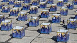 Un hombre camina entre paneles que exhiben retratos de combatientes caídos de la Brigada Azov, instalados en la plaza de Santa Sofía, en el centro de Kiev, en medio de la invasión rusa de Ucrania.
