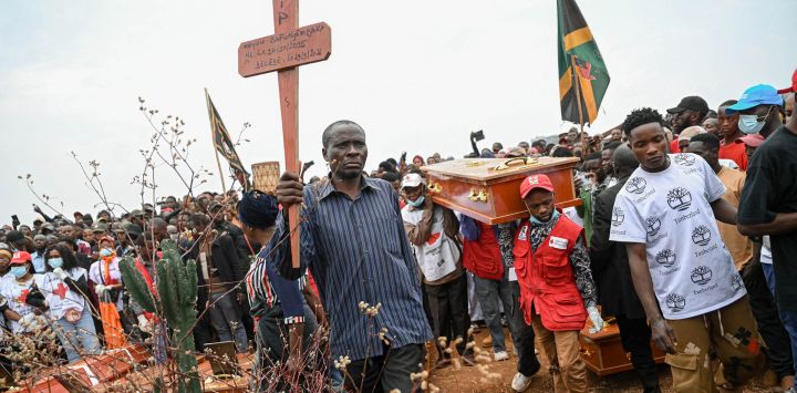 Bafunyembaka Lusirha llega al cementerio de Ruzizi portando la cruz de su hija, Mugoli Bafunyembaka, de 9 años, fallecida en un incendio. Bafunyembaka se prepara para participar en el entierro colectivo, tras la ceremonia fúnebre oficial por los niños que perdieron la vida en el siniestro ocurrido en Bukavu. Un incendio y una estampida en una escuela del este de la República Democrática del Congo causaron la muerte de al menos 26 niños —según informó la agencia de la ONU para la infancia—; algunos alumnos saltaron desde ventanas de plantas altas para escapar de la tragedia.