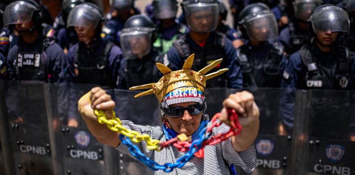 Un familiar de un preso político se manifiesta frente a un cordón policial durante una protesta para exigir la liberación de detenidos y denunciar el incumplimiento de las liberaciones de presos anunciadas previamente, cerca del Palacio Presidencial de Miraflores en Caracas, Venezuela.