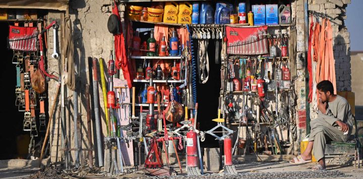 Un hombre afgano está sentado frente a una tienda en una calle del distrito de Spin Boldak, en la provincia afgana de Kandahar.