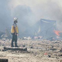 Un rescatista sirio de los "Cascos Blancos", inspecciona el lugar de una explosión ocurrida en un depósito provisional de armas y municiones en la localidad de Samarda, en la provincia de Idlib. Una explosión en un depósito de armas en la provincia de Idlib, en el noroeste de Siria, causó la muerte de 14 personas, según informó el departamento de salud local, sin precisar la causa del estallido. | Foto:Abdulaziz Ketaz / AFP