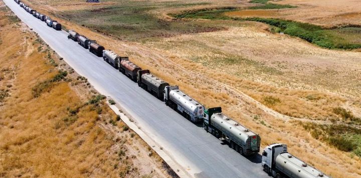 Esta vista aérea muestra camiones cisterna de petróleo detenidos mientras los residentes bloquean la autopista M4 en Tal Tamr, en la provincia nororiental siria de Hasaka, impidiendo su paso desde el noreste de Siria hacia las refinerías gubernamentales en protesta por las recientes subidas de los precios del combustible.