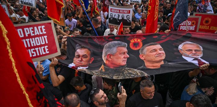 Un grupo de albanokosovares sostiene una pancarta con imágenes que muestran (de izquierda a derecha) al excomandante del ELK Rexhep Selimi, al exlíder político del ELK Hashim Thaci, al exalto mando y jefe de inteligencia del ELK Kadri Veseli y al exportavoz del ELK Jakup Krasniqi durante la "Marcha por la Libertad" en Pristina, cuatro días antes de que se anuncie el veredicto del juicio por crímenes de guerra contra Hashim Thaci.