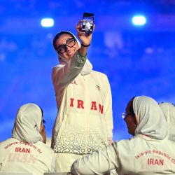 Un miembro de la delegación de Irán se toma una selfi durante el desfile de la ceremonia de inauguración de los Juegos Asiáticos de 2026 en el Estadio Paloma Mizuho de Nagoya. | Foto:Mohd Rasfan / AFP