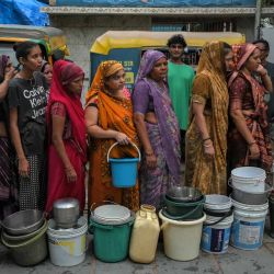Residentes hacen fila para llenar sus recipientes con agua potable de un camión cisterna público en Ahmedabad, | Foto:AFP