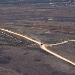Esta imagen, tomada desde una posición en la región de la Alta Galilea, en el norte de Israel, muestra un vehículo militar israelí circulando por una carretera en el sur del Líbano el 20 de septiembre de 2026. Israel ha estado ocupando una franja del sur del Líbano desde que estalló la guerra en marzo contra el grupo militante libanés Hezbolá; sin embargo, se prevé que el ejército libanés asuma gradualmente el control de la zona en virtud de un acuerdo marco entre ambos países | Foto:AFP