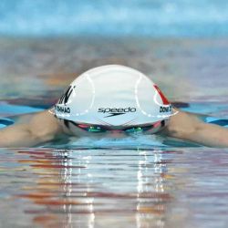 El chino Dong Zhihao compite en una serie de la prueba masculina de 100 metros braza durante los Juegos Asiáticos de 2026, en el Centro Acuático de Tokio, el 21 de septiembre de 2026 | Foto:AFP
