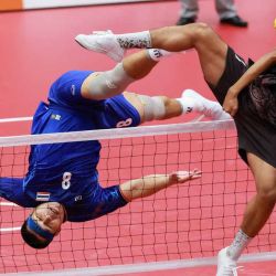 El tailandés Pichet Pansan (izq.) golpea el balón con el pie durante el partido de *sepak takraw* (modalidad *regu* por equipos masculinos) entre Tailandia e Indonesia, en el gimnasio Nagoya City Mizuho Park de Nagoya, el 21 de septiembre de 2026. | Foto:AFP