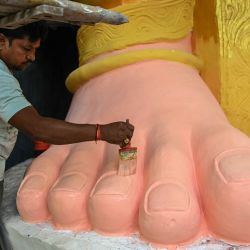 Un trabajador pinta el pie de una imagen de la deidad hindú Ganesha, con cabeza de elefante, antes del festival Ganesh Chaturthi en Hyderabad, India. | Foto:NOAH SEELAM / AFP