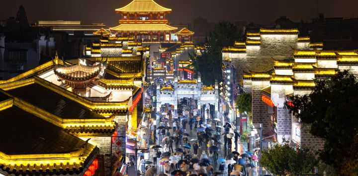 Imagen de personas visitando el poblado antiguo de Xiangyang en la noche, en Xiangyang, en la provincia de Hubei, en el centro de China. En los últimos años, Xiangyang, ha estado promoviendo el turismo mediante espectáculos de luces, cruceros nocturnos, presentaciones en vivo y mercados nocturnos.