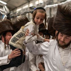 Hombres judíos ultraortodoxos ayudan a un niño a llegar hasta el rabino antes de la tradicional ceremonia de *Malkot*, pocas horas antes del inicio de Yom Kipur —el día sagrado judío de la Expiación—, en una sinagoga de la ciudad de Beit Shemesh, en el distrito de Jerusalén, Israel. Yom Kipur, también conocido como el Día de la Expiación, es una de las festividades más importantes del año judío, durante la cual los israelíes observan un periodo de 25 horas de ayuno, reflexión y oración. | Foto:Ilia Yefimovich / AFP