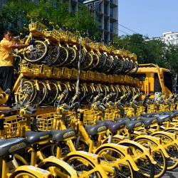 Un trabajador descarga bicicletas de uso compartido de un camión en una calle de Pekín. | Foto:Wang Zhao / AFP
