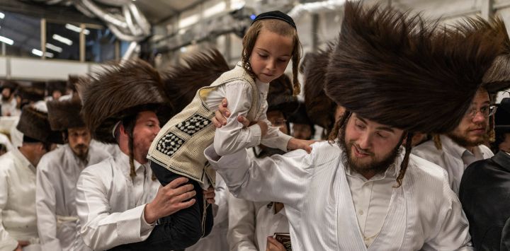 Hombres judíos ultraortodoxos ayudan a un niño a llegar hasta el rabino antes de la tradicional ceremonia de *Malkot*, pocas horas antes del inicio de Yom Kipur —el día sagrado judío de la Expiación—, en una sinagoga de la ciudad de Beit Shemesh, en el distrito de Jerusalén, Israel. Yom Kipur, también conocido como el Día de la Expiación, es una de las festividades más importantes del año judío, durante la cual los israelíes observan un periodo de 25 horas de ayuno, reflexión y oración.