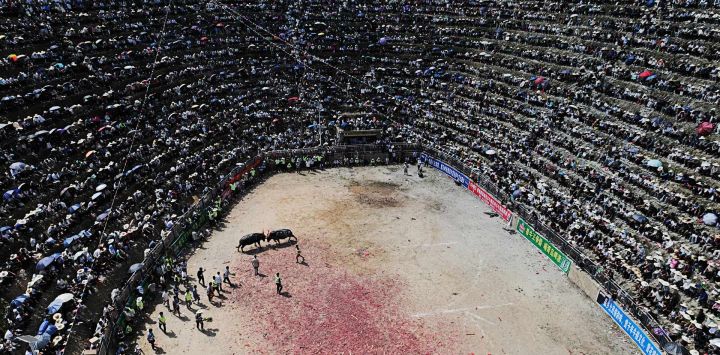 Personas observan una corrida de toros en Zaibian, en el condado de Congjiang, provincia de Guizhou, suroeste de China.