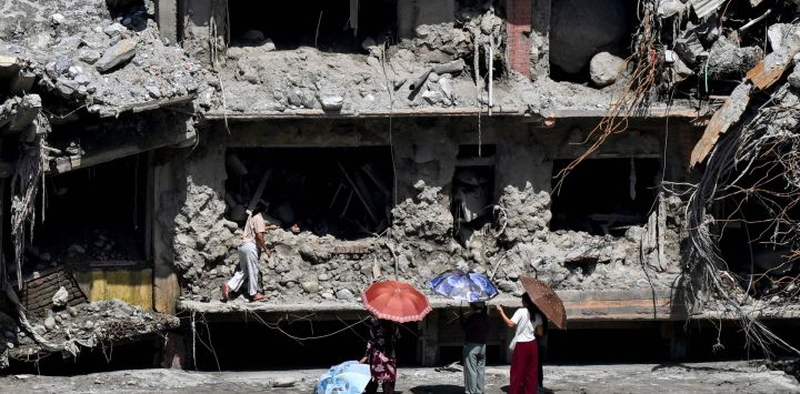Unas personas observan una casa dañada por la repentina inundación en Trishuli, en el distrito nepalí de Nuwakot. La catastrófica inundación del 26 de agosto fue provocada por el colapso de un glaciar en la cordillera del Himalaya, en la frontera entre China y Nepal, un fenómeno que los científicos han vinculado al cambio climático. Las aguas, que avanzaron con la fuerza de un tsunami, arrasaron distritos montañosos, destruyendo carreteras, puentes y presas hidroeléctricas, y causaron la muerte de al menos 1.446 personas.