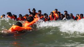 Un grupo de migrantes intenta subir a una embarcación de traficantes frente a la playa de Equihen-Plage, en el norte de Francia.