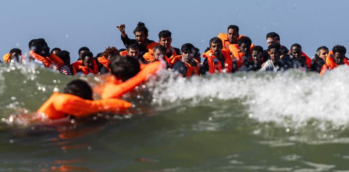 Un grupo de migrantes intenta subir a una embarcación de traficantes frente a la playa de Equihen-Plage, en el norte de Francia.