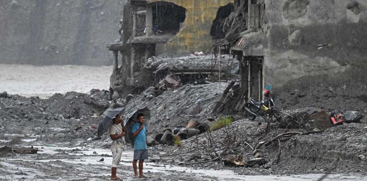 Unos hombres caminan junto a casas anegadas tras la repentina inundación del 26 de agosto, en Trishuli (distrito de Nuwakot, Nepal). La nación del Himalaya sufrió una de las peores catástrofes de su historia a finales del mes pasado, cuando una inundación similar a un tsunami —provocada por el colapso de un glaciar de alta montaña en la frontera entre Nepal y China— dejó un rastro de destrucción a su paso. Más de 1.400 personas perdieron la vida, 6.000 siguen desaparecidas y los daños económicos ascienden a miles de millones de dólares.