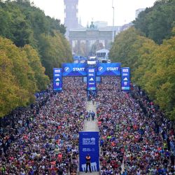 Los corredores toman la salida de la 52.ª edición del Maratón de Berlín en Berlín, Alemania, con el Ayuntamiento Rojo y la Puerta de Brandeburgo visibles al fondo. | Foto:JOHN MACDOUGALL / AFP