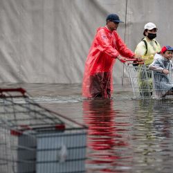 Una familia avanza con un carro a través de las aguas de la inundación en el distrito de Bang Kapi, en Bangkok. Miles de residentes de Bangkok amanecieron en refugios después de que las inundaciones, provocadas por días de fuertes lluvias en la capital tailandesa, anegaran viviendas y carreteras; algunos ya han comenzado a secar sus hogares y pertenencias. | Foto:Chanakarn Laosarakham / AFP